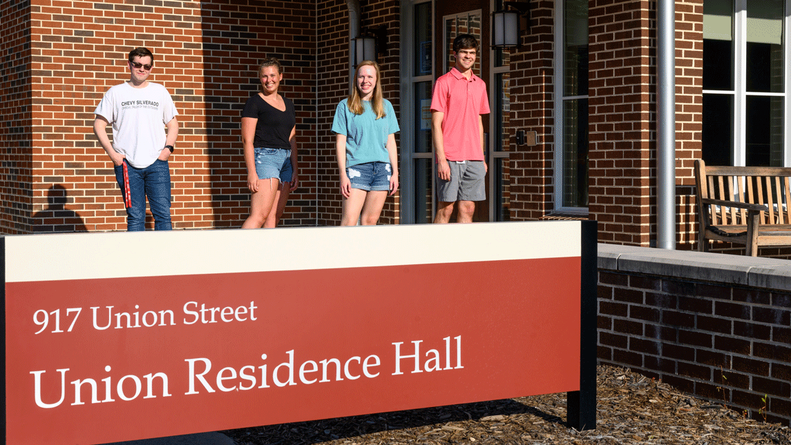 students in front of a residence hall