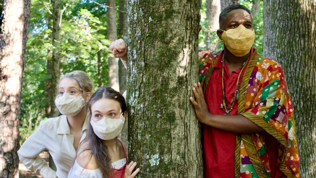 theatrical performers in a woods setting