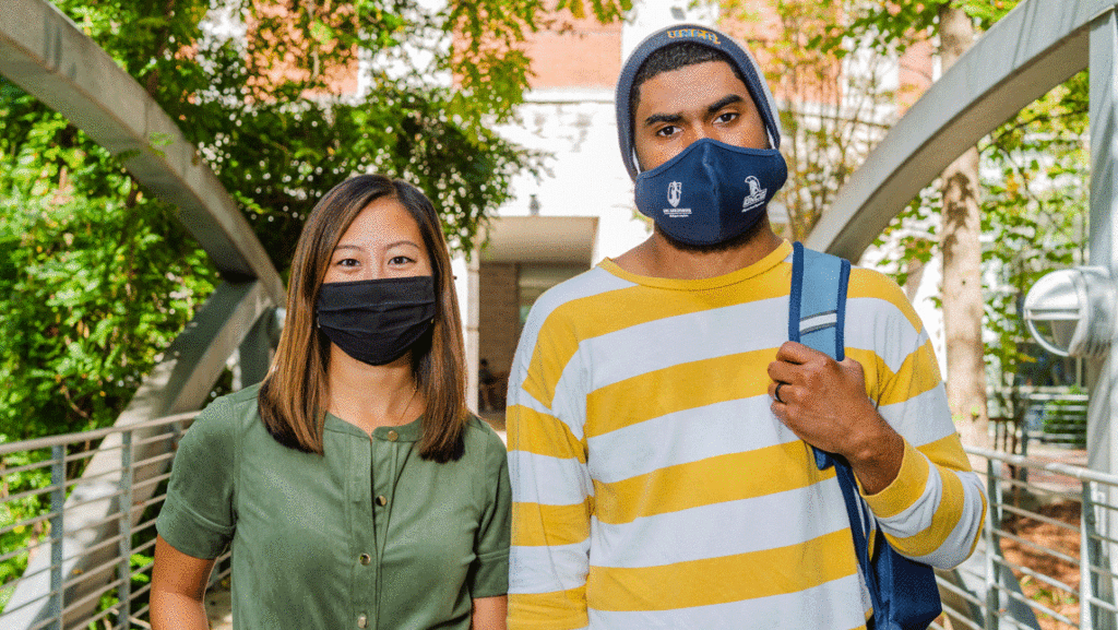 woman and man on a bridge, wearing masks