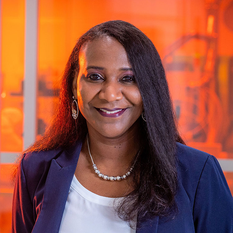 UNCG's Dr. Obare stands at the window of a lab in the Joint School of Nanoscience and Nanotechnology building.