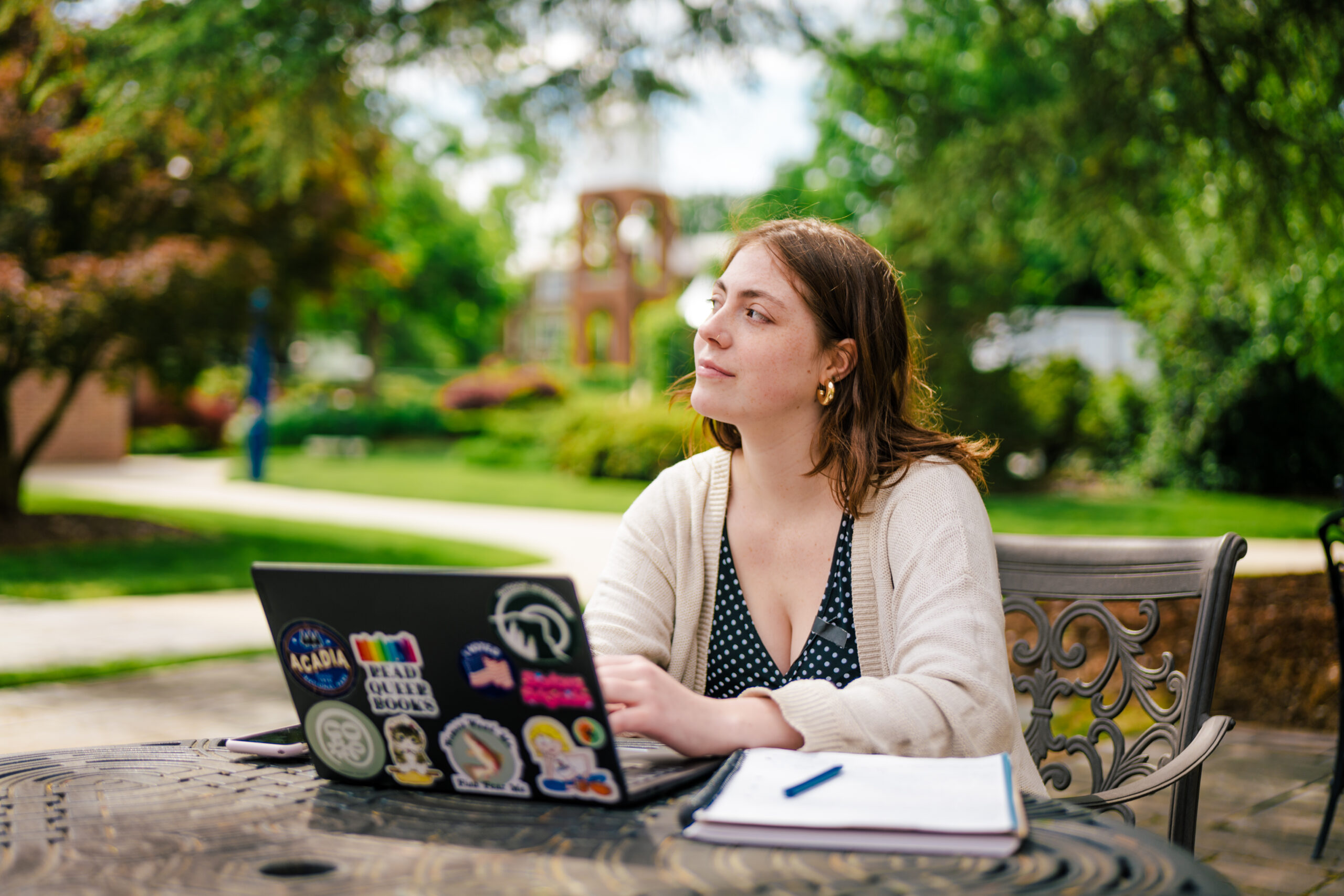 Student with a laptop working outside on the UNCG campus.