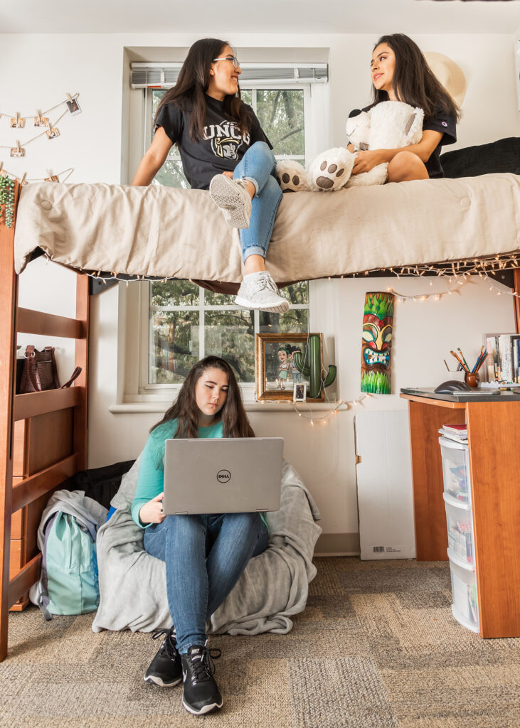 Three female students in their residence hall room.