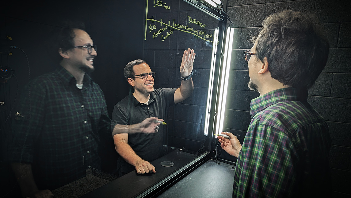 Faculty at UNCG shoot video using a lightboard.