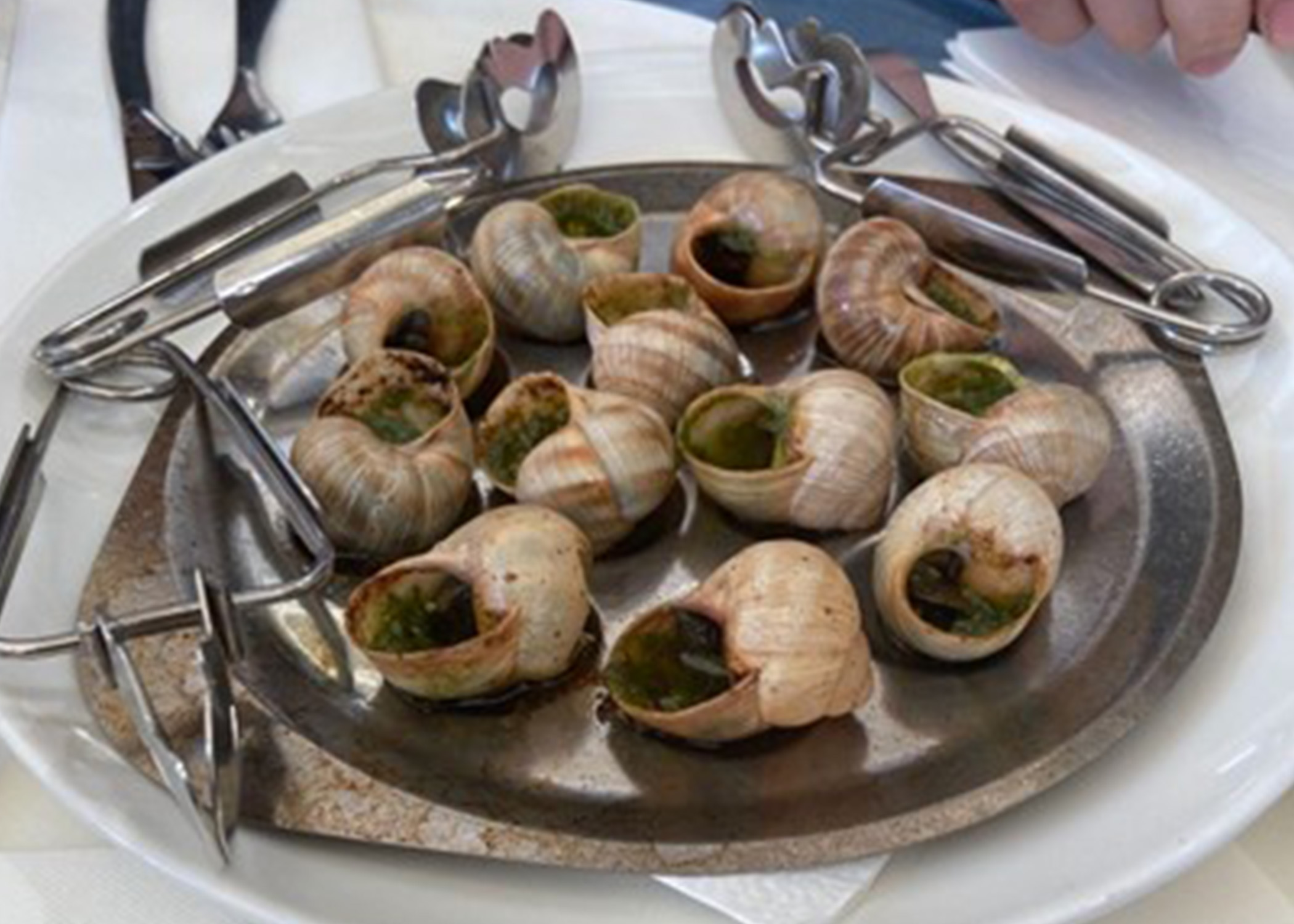 Escargot on a plate with white linens.