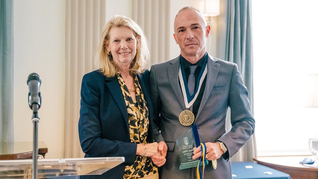 UNCG English professor Christian Moraru receives an award from Vice Chancellor for Research and Engagement Terri Shelton.