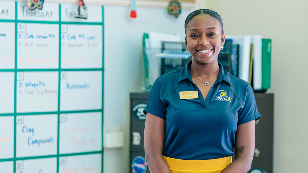 UNCG student Victoria Howard poses in a middle school classroom.
