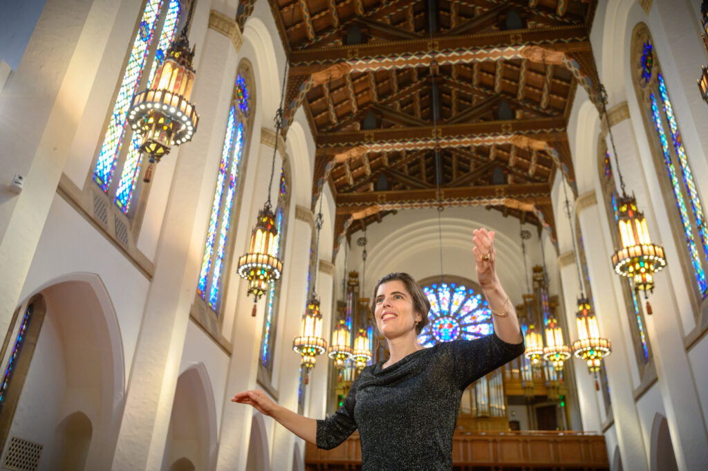 Woman holds her arms up in a church