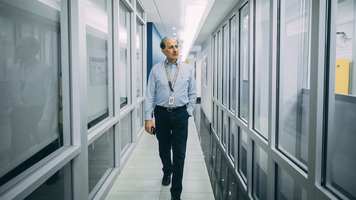 JSNN Director, Research Operations and Environmental Health and Safety, Mahdi Fahim walking down a hallway.