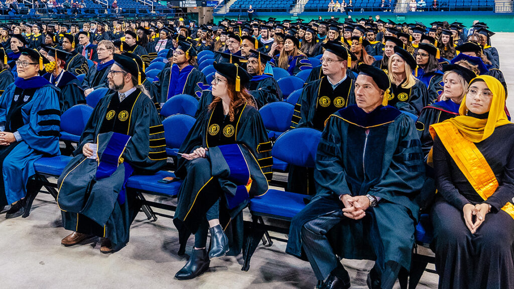 Doctoral students sit together at the UNCG graduate Commencement ceremony.