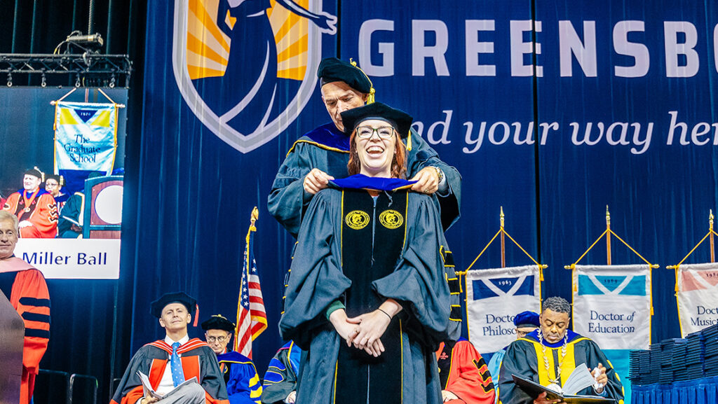Doctoral student receives hooding at UNCG graduate ceremony.