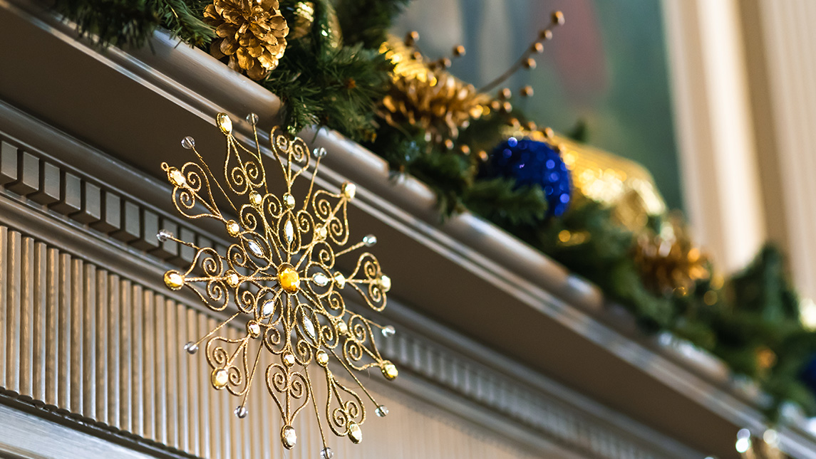 A snowflake ornament hangs from the mantle inside the UNCG Alumni House.