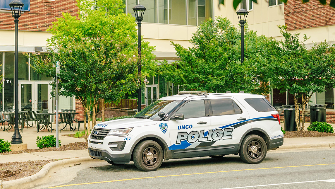 A UNCG police cruiser parked on the street.