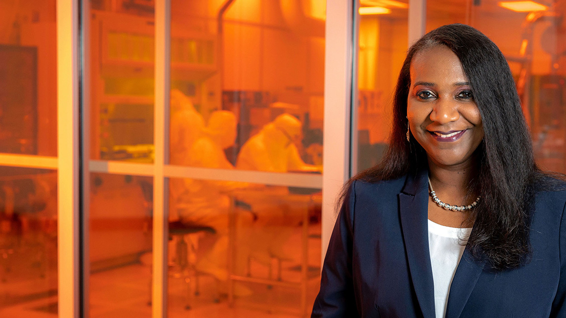 UNCG's Dr. Obare stands at the window of a lab in the Joint School of Nanoscience and Nanotechnology building.