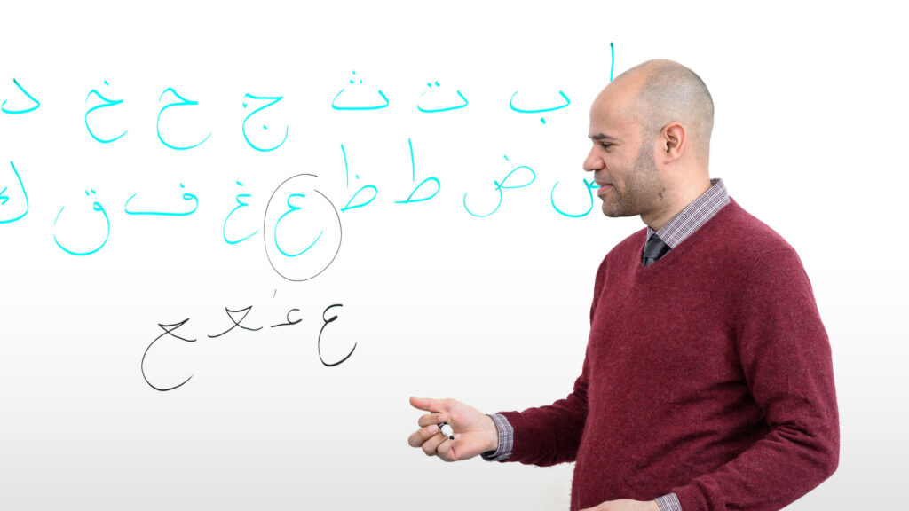 UNCG Professor Wiley looks at the Arabic language written on a whiteboard.