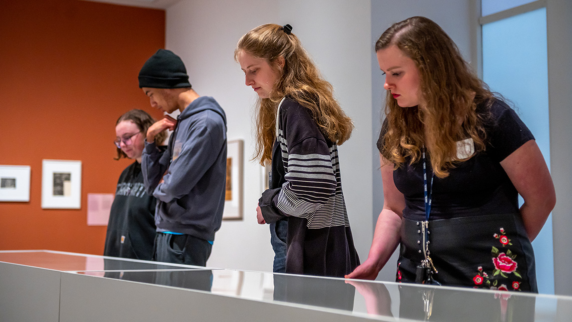 Four UNCG students look into a display at the Weatherspoon Art Museum.