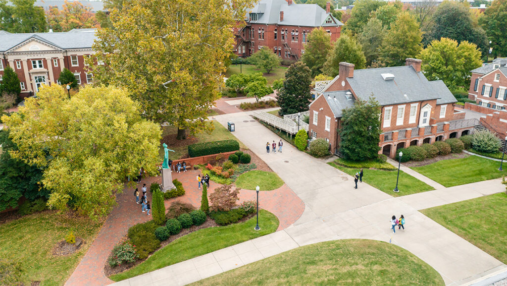 A drone overlook image of UNCG's College Ave, Faculty Center, and Minerva statue.