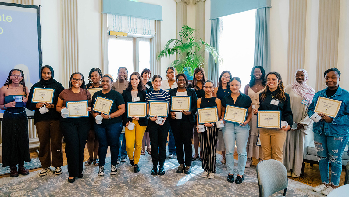 A group of UNCG students hold up certificates.