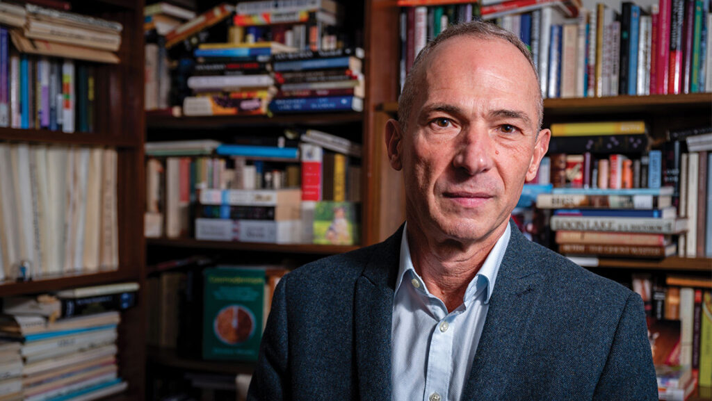 UNCG English Professor Christian Moraru in front of a bookshelf