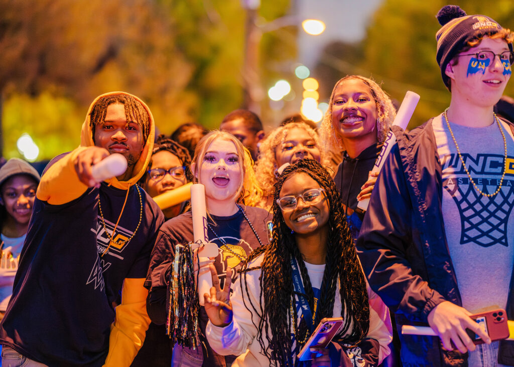 UNCG students parade to the Greensboro coliseum for the first basketball game of the season.