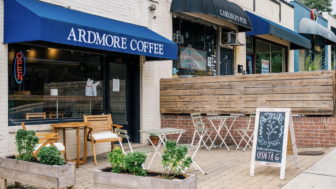 Ardmore Coffee storefront with blue awning, table and chairs for outdoor seating.