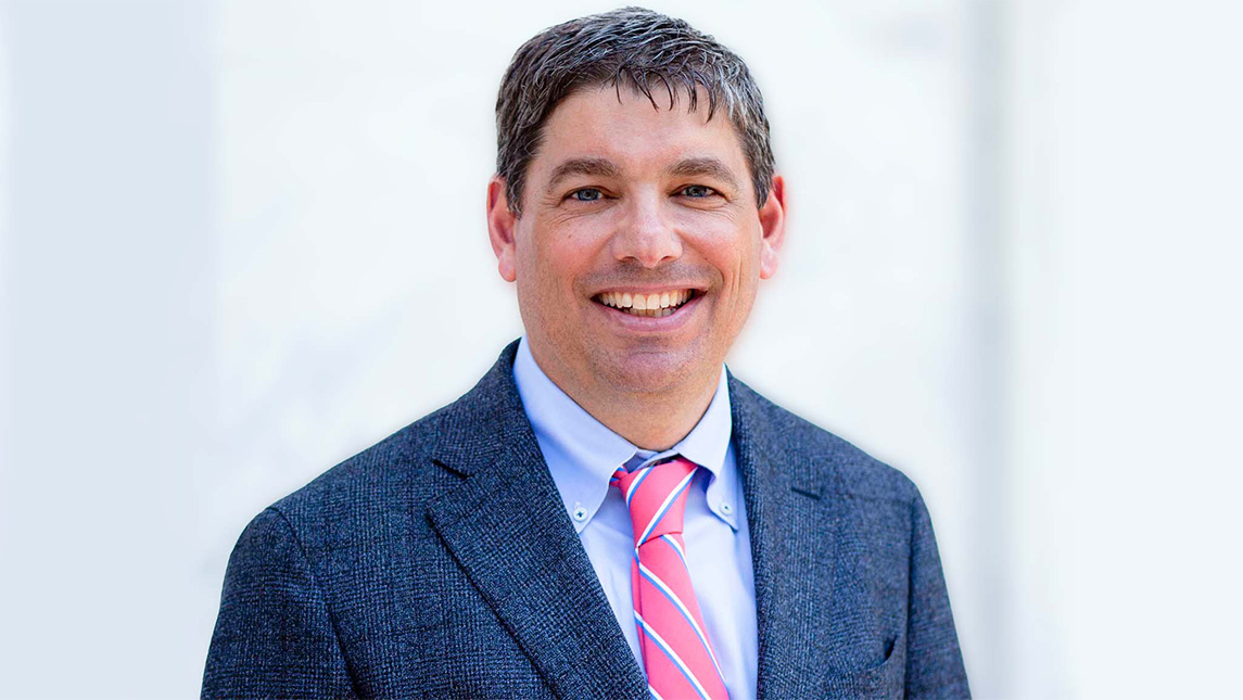 A headshot of a man in professional clothing.