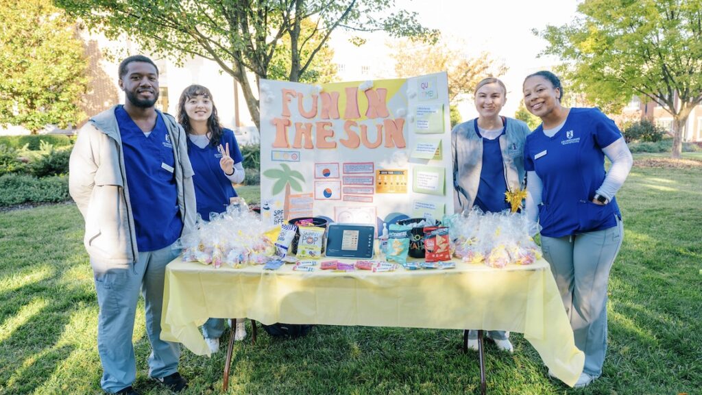 The UNCG School of Nursing Community Students pose at a table that for a health fair.