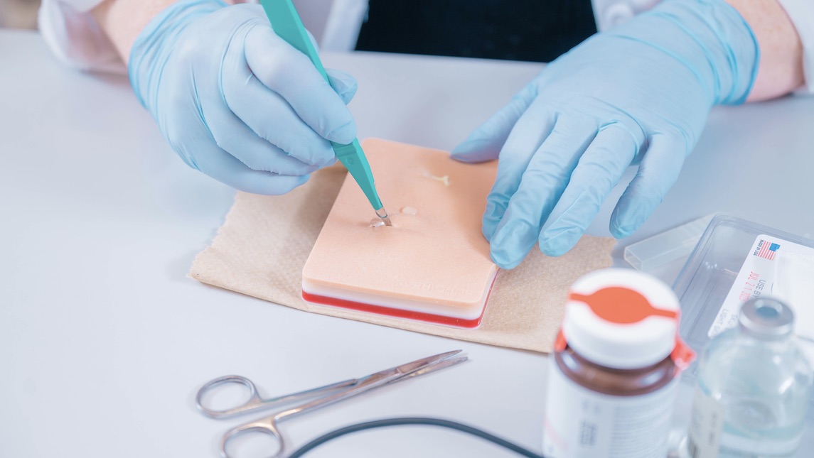 Students in the new Family Nurse Practitioner concentration at UNCG's School of Nursing practice cutting on fake skin.