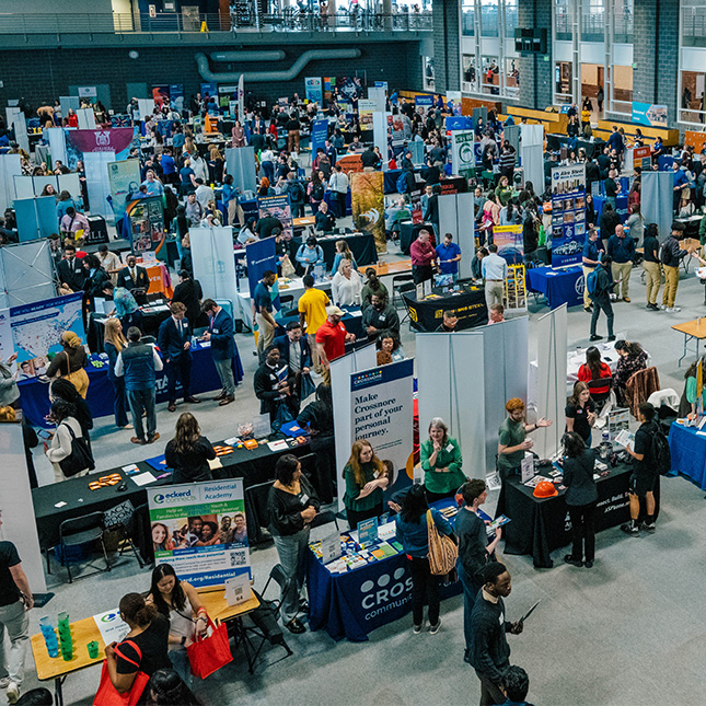 Overhead shot of crowded event space with tables set up.