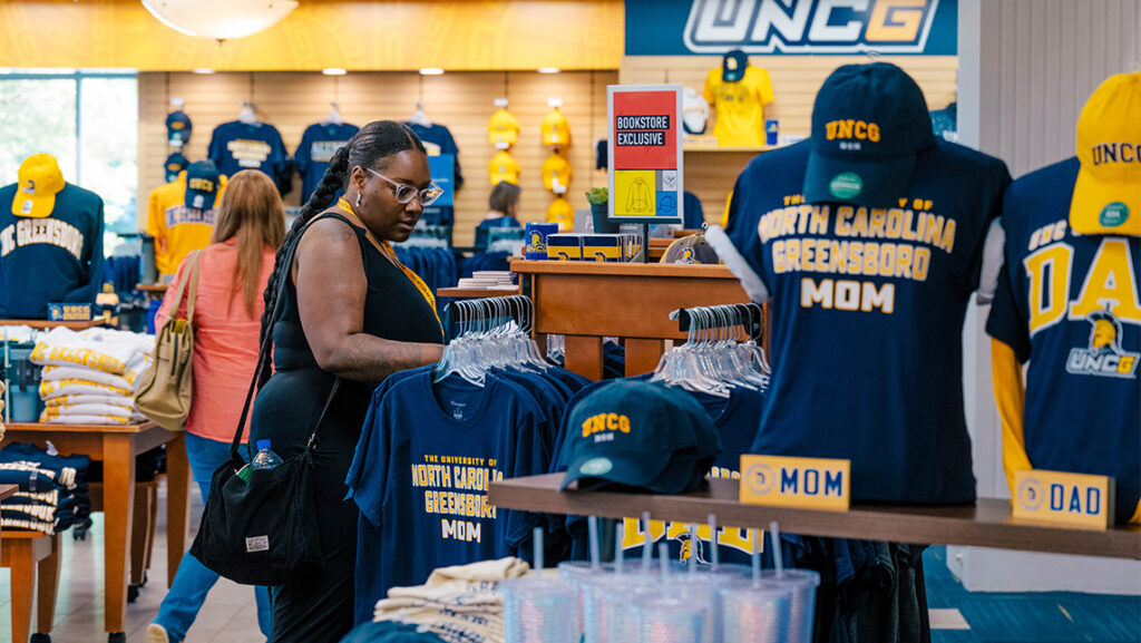 A mother of a student shops for UNCG-branded apparel at the bookstore.