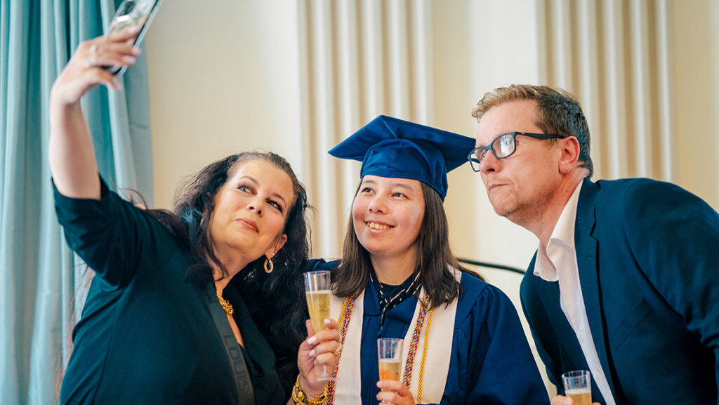 Parents take a selfie with their child, a recent UNCG graduate.