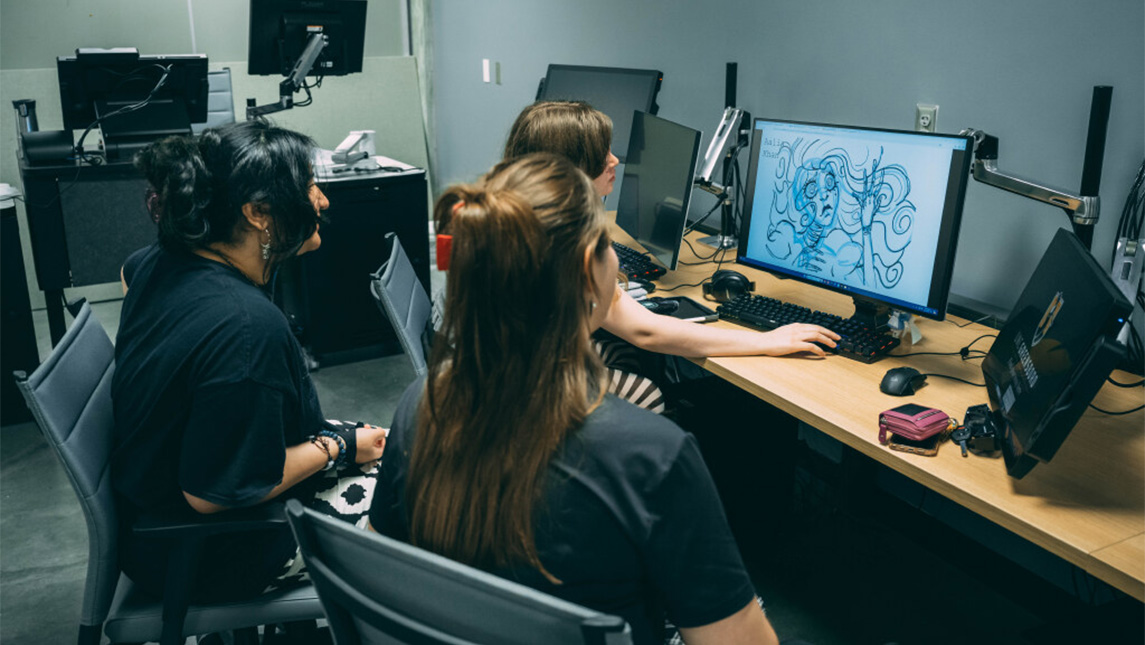 UNCG students work on an animation at a computer station.