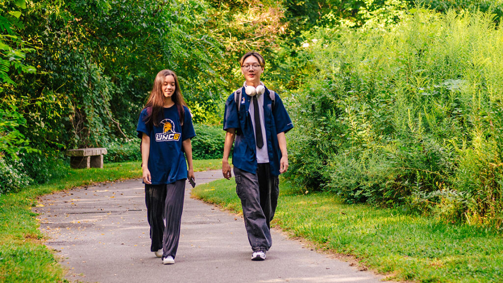 Students walk along the golf course path at UNCG.