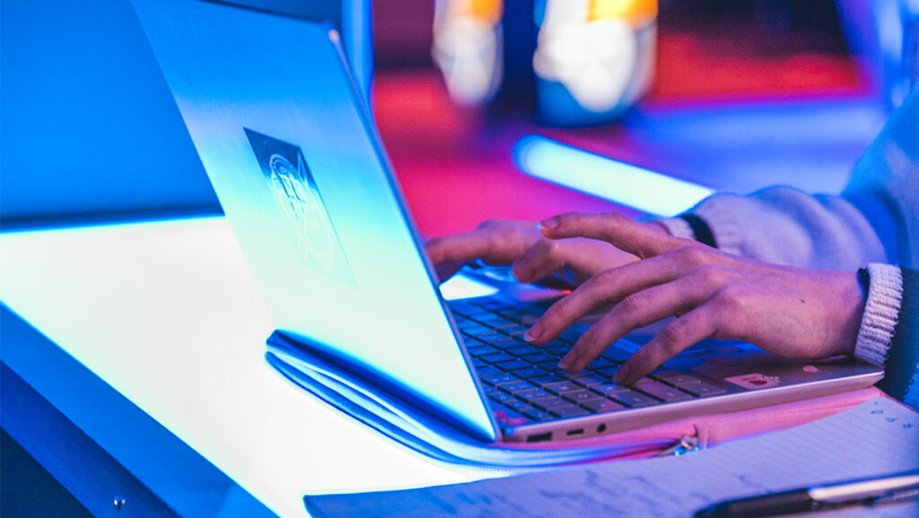 Close-up of hands working on a laptop.