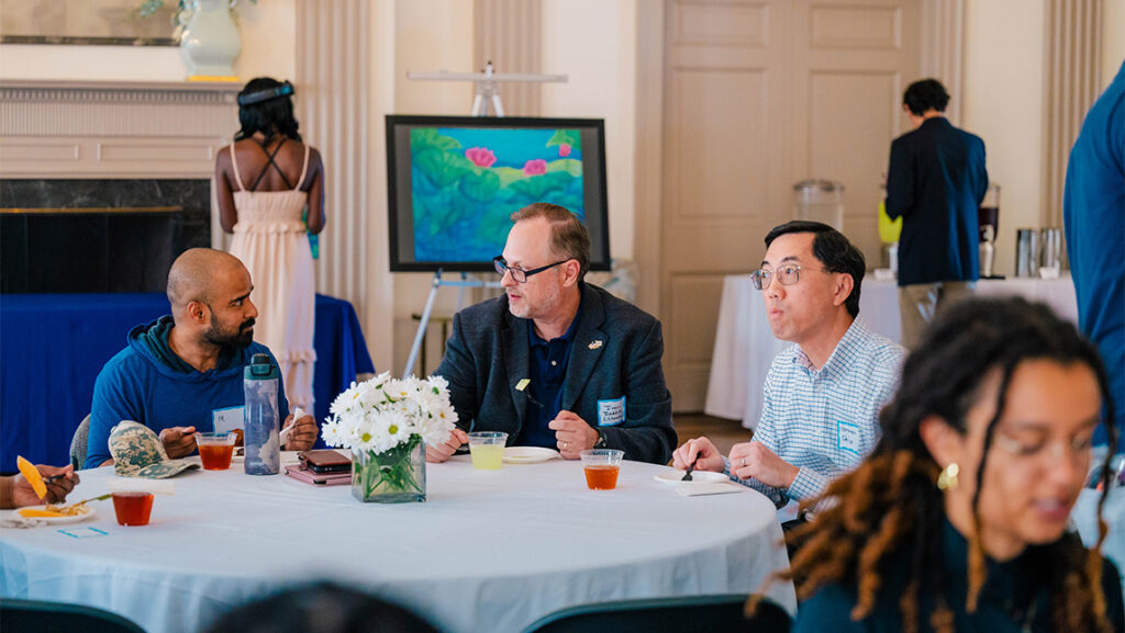 Students and faculty sit and chat in the UNCG Alumni House.