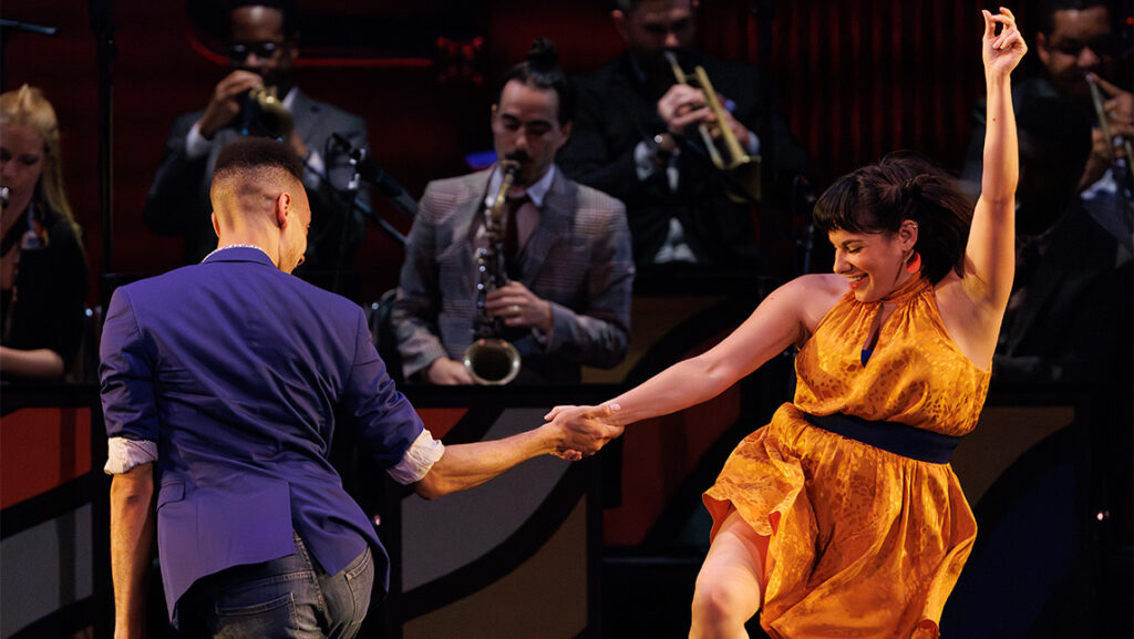 A couple dances in front of of a jazz band.