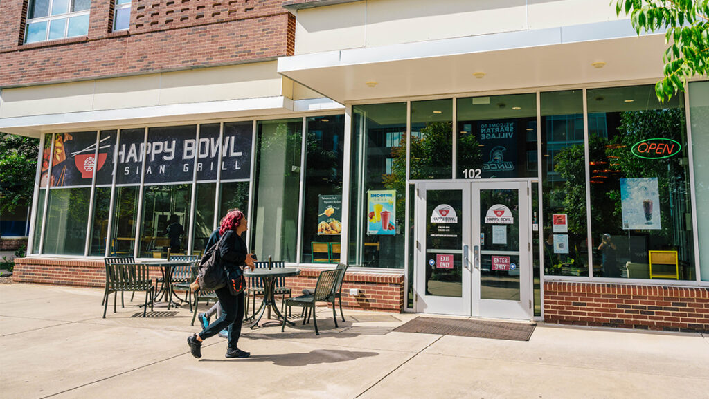 A student walks up to Happy Bowl at UNCG's Spartan Village.