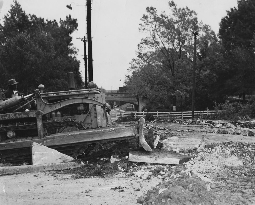 Black and white photo of a bridge being demolished at UNCG.