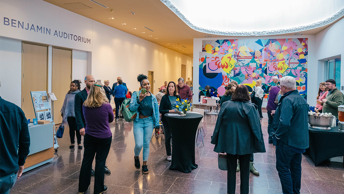 People mill about the UNCG Weatherspoon Art Museum lobby.