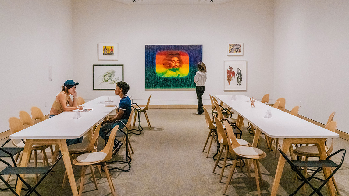 Students look at art or talk at a table at the UNCG Weatherspoon Art Museum.