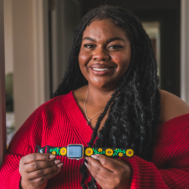 Student shows off an Apple watch with a sunflower band. 