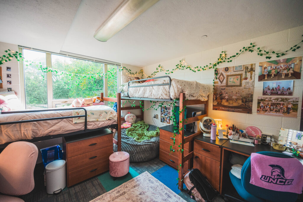 Dorm room decorated with pastel colors, raised beds and a comfy bean bag.