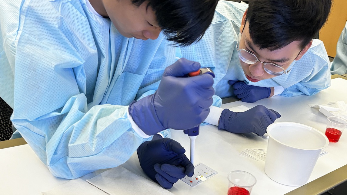 Two male high school students in the JSNN lab working.