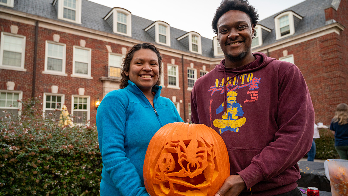 Two students from the UNCG Strong Residential College show off their winning jack-o-lantern.