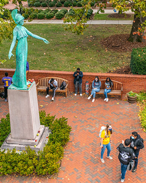 Drone shot of campus showing students and Minerva statue.