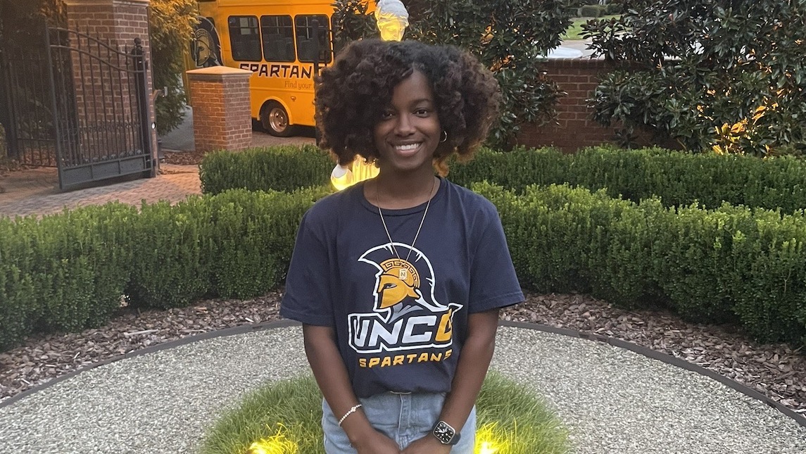 UNCG SON alumna Nykeria Spellmon poses with a UNCG Spartan shirt.