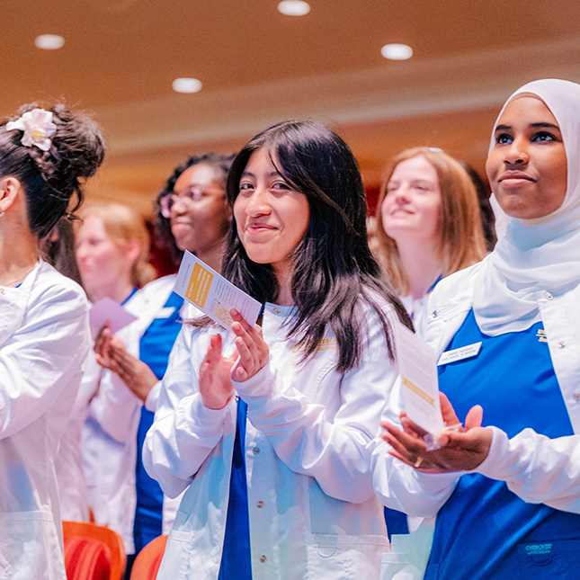 Nursing students stand and smile at camera.