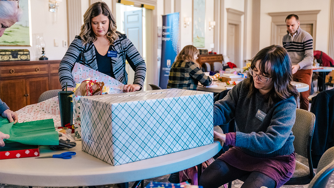 Members of the UNCG Staff Senate wrap gifts that will go to families of the Angel Tree program.