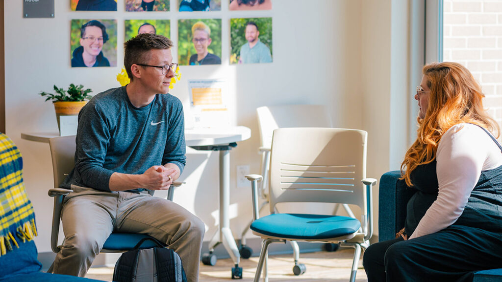 Two people talk inside UNCG's Spartan Recovery center.