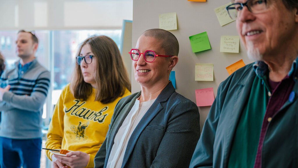 UNCG's Jennifer Whitney listens to a speech at the Spartan Recovery facility.