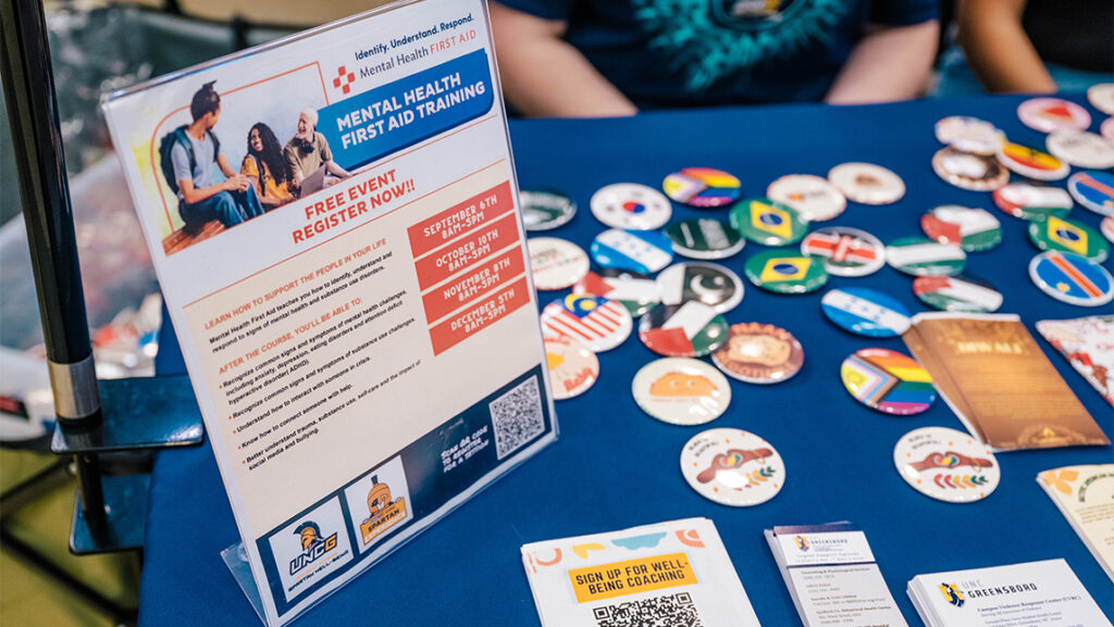 Buttons and banners promote wellness initiatives on the UNCG campus.